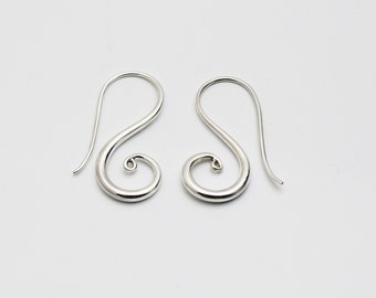 Puede incluir: Un par de pendientes de plata con un diseño en espiral. Los pendientes están hechos de un metal liso y brillante y tienen un aspecto simple y elegante.