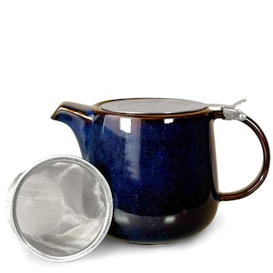 May include: A deep blue ceramic teapot with a glossy finish, featuring a dark brown rim and handle. The teapot includes a stainless steel lid and a separate cylindrical fine-mesh metal tea infuser basket placed in front of the main vessel.