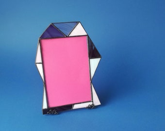 Unusual artistic photo frame. Stained glass frame made of purple, pink and white glass. Geometric frame of triangles