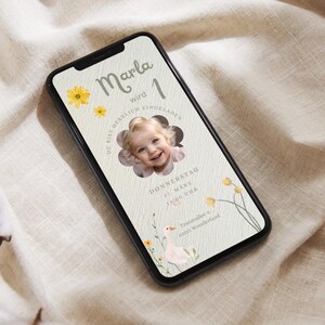 Puede incluir: Una invitaci&oacute;n digital en la pantalla de un tel&eacute;fono inteligente para una fiesta de primer cumplea&ntilde;os. La invitaci&oacute;n es para la fiesta de primer cumplea&ntilde;os de Marla, que se celebrar&aacute; el jueves 17 de marzo a las 14:00. La invitaci&oacute;n presenta un dise&ntilde;o de flores amarillas y una foto de una ni&ntilde;a.