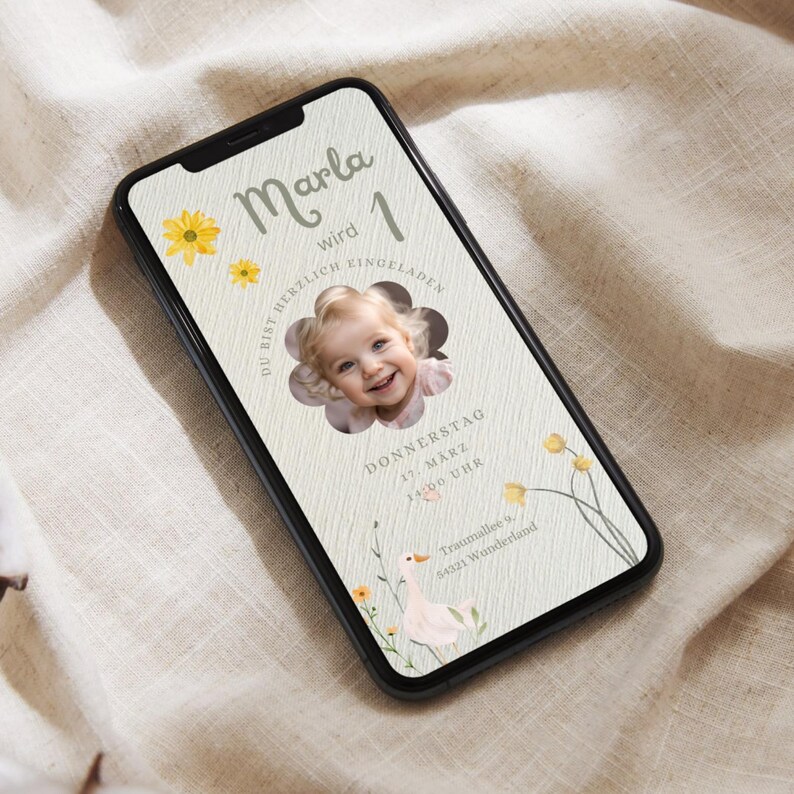 Puede incluir: Una invitaci&oacute;n digital en la pantalla de un tel&eacute;fono inteligente para una fiesta de primer cumplea&ntilde;os. La invitaci&oacute;n es para la fiesta de primer cumplea&ntilde;os de Marla, que se celebrar&aacute; el jueves 17 de marzo a las 14:00. La invitaci&oacute;n presenta un dise&ntilde;o de flores amarillas y una foto de una ni&ntilde;a.