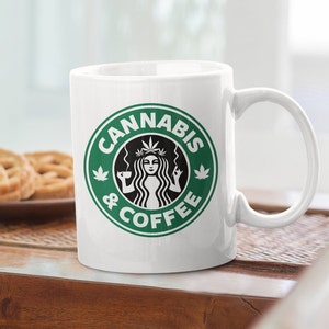 May include: White ceramic mug with a green and black logo that says "Cannabis & Coffee". The logo features a stylized woman with a cannabis leaf in her hair holding a cup of coffee.