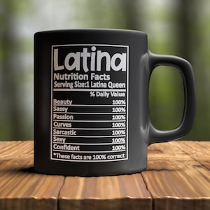 Puede incluir: Taza de cerámica negra con un diseño blanco que dice "Latina Nutrition Facts Serving Size: 1 Latina Queen" con una lista de rasgos y un valor porcentual del 100% para cada rasgo. Los rasgos enumerados son Belleza, Sassy, Pasión, Curvas, Sarcástica, Sexy y Confianza. El texto en la parte inferior dice "*Estos datos son 100% correctos"