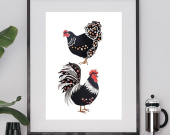 Op de afbeelding: Ingelijste kunstdruk met een illustratie van een kip en een haan. De zwart-witte vogels hebben rode accenten en bloemendetails. Het kunstwerk wordt tentoongesteld op een witte kast in een eetkamer.