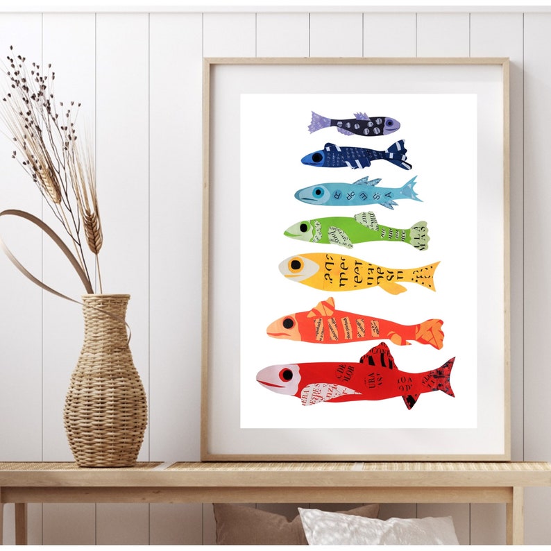 Pode incluir: Uma impress&atilde;o emoldurada de um arco-&iacute;ris colorido de peixes, cada um feito de papel e com texto neles. Os peixes est&atilde;o dispostos verticalmente, com o menor na parte superior e o maior na parte inferior. Os peixes est&atilde;o nas cores do arco-&iacute;ris, come&ccedil;ando com o azul e terminando com o vermelho.