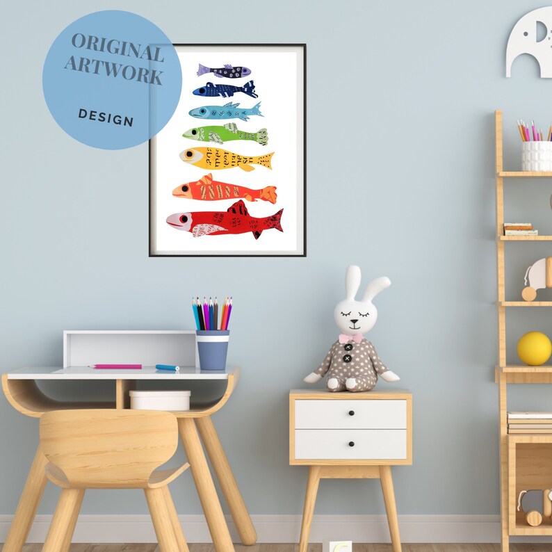 Pode incluir: Uma impress&atilde;o emoldurada de peixes coloridos com diferentes padr&otilde;es e designs. Os peixes est&atilde;o dispostos verticalmente em um padr&atilde;o de arco-&iacute;ris. A impress&atilde;o est&aacute; pendurada em uma parede azul clara em um quarto de crian&ccedil;a.