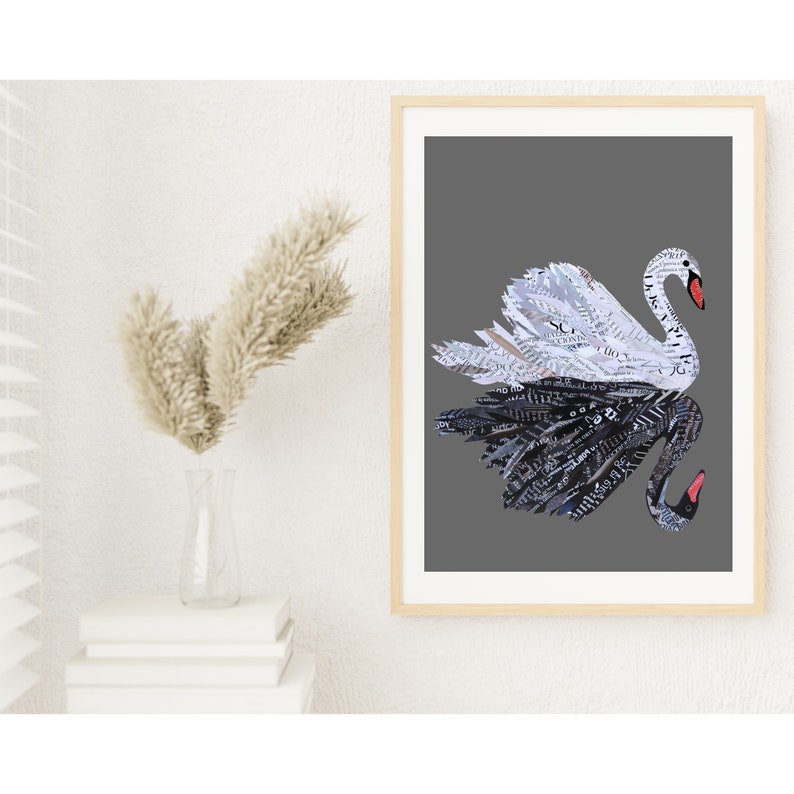 May include: A framed print of a black and white swan made from paper. The swan is depicted in a stylised, abstract way, with its wings spread wide. The background is a solid grey colour.