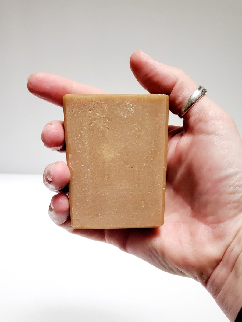 May include: A rectangular bar of brown soap with a slightly grainy texture.
