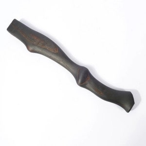 May include: A dark grey wooden carving with a smooth, curved surface. The carving has a unique, organic shape and is reminiscent of a stylised branch.