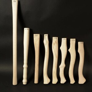 Puede incluir: Nueve mangos de hacha de madera de diferentes longitudes, etiquetados con los números V6, V14, V9, V7, V13, V10, V10, V12 y V23.