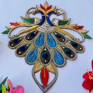 May include: A blue and gold embroidered peacock design with red accents. The peacock has a detailed tail with blue, green, and gold feathers.