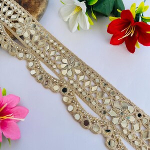 2.75 inch wide scallop mirror trim in gold color featuring intricate Indian embroidery and reflective mirror work, ideal for waist wear jewelry, kamarband designs, lehenga borders, saree edging, blouse decoration, bridal costumes, festive ethnic outfits, dance wear, DIY fashion projects, and traditional Indian garment embellishment with luxury handcrafted finish