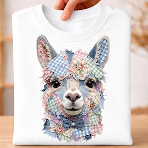 May include: White sweatshirt featuring a colorful patchwork llama design. The llama's face is adorned with floral and gingham patches, a blue bow tie, and large, expressive eyes. The sweatshirt is held up by a hand.