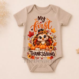 May include: A beige short-sleeved baby bodysuit featuring a graphic of a turkey wearing a hat, sitting in a pumpkin, surrounded by autumn leaves and sunflowers. The text reads My first THANKSGIVING in brown and orange lettering on the front.