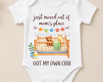 May include: White baby onesie with the text "just moved out of mom's place" and "got my own crib". The design includes a crib with a teddy bear and a bunny. A colorful star banner is above the crib.