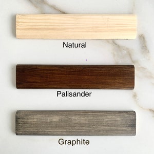 May include: Three wood samples showing different color options: Natural, Palisander, and Graphite.