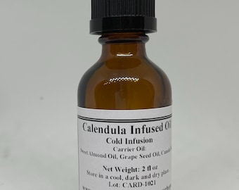 May include: A brown glass bottle with a black dropper top, labeled "Calendula Infused Oil" with the text "Cold Infusion Carrier Oil: Sweet Almond Oil, Grape Seed Oil,  Net Weight: 2 fl oz Lot: CARD-1021 www.etsy.com/shop/shopyourboy"