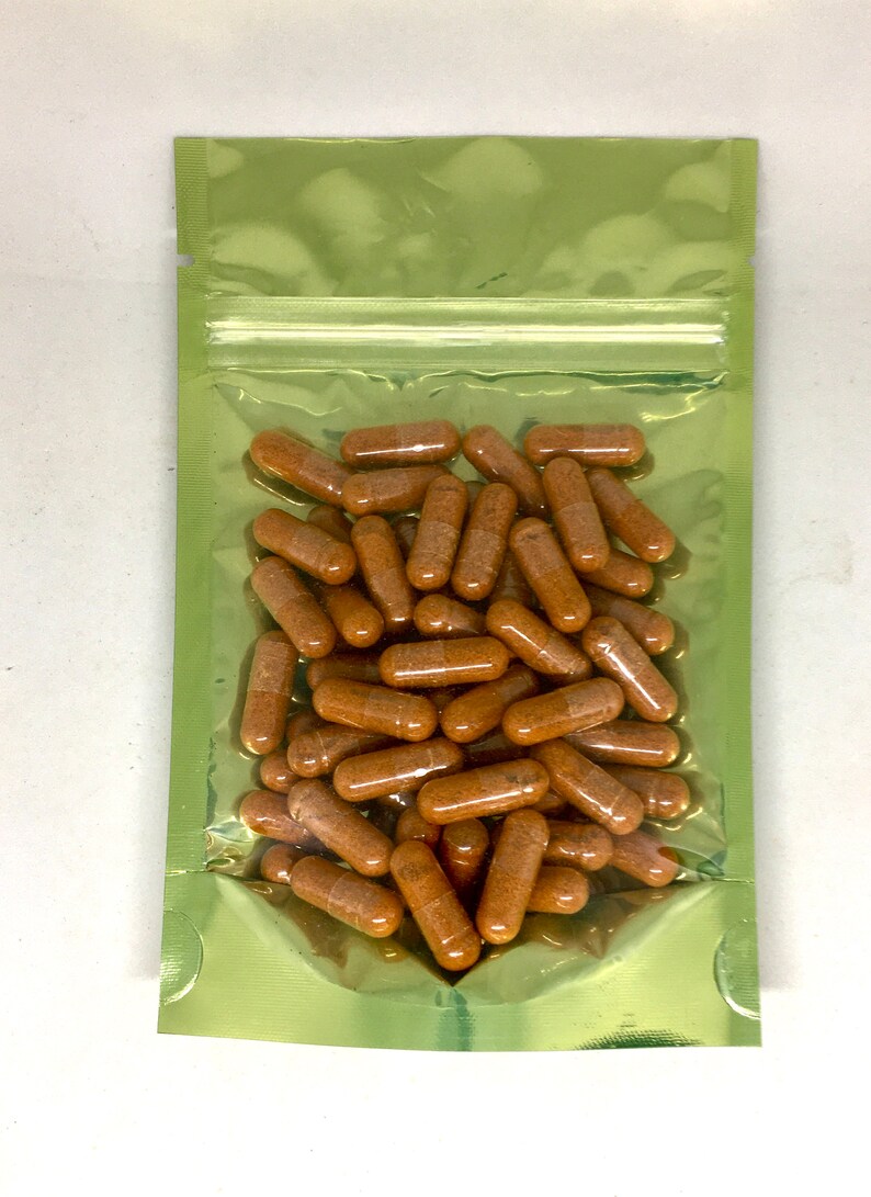 Op de afbeelding: Een groene hersluitbare zak gevuld met een grote hoeveelheid bruine capsules.