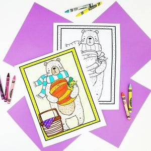 May include: Two coloring pages featuring cartoon bears, one colored and one outlined. The colored bear holds a pumpkin and wears a blue scarf. Crayons in various colors are scattered around the pages on a white surface with purple paper accents. The pages are framed in yellow.