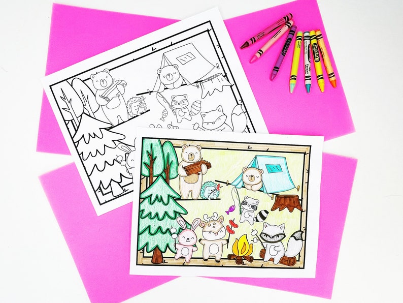 May include: Two coloring pages featuring a camping theme with cartoon animals, one colored and one uncolored. The colored page shows a bear, rabbit, deer, raccoon, and fox around a campfire. Crayons in various colors are arranged on a pink background.