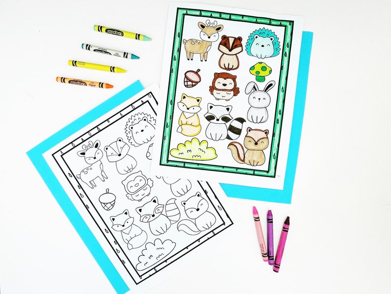 May include: Two coloring pages with woodland animal illustrations, including a deer, fox, and raccoon, are displayed with crayons. One page is colored with green, yellow, and brown. Crayons in various colors are scattered around the pages.
