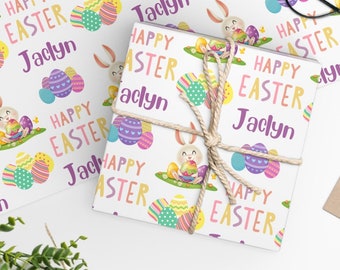 May include: White wrapping paper with a repeating pattern of pastel colored Easter eggs, a bunny holding an egg, and the text "Happy Easter Jaclyn".