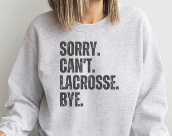 May include: Gray sweatshirt with the text "SORRY. CAN'T. LACROSSE. BYE." printed on the front.