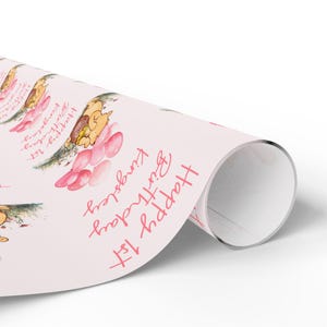 May include: Pink wrapping paper with a repeating pattern of a cartoon animal holding pink balloons and the text "Happy 1st Birthday".
