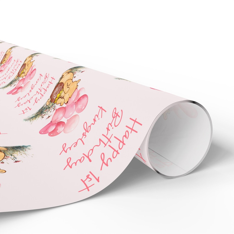 May include: Pink wrapping paper with a repeating pattern of a cartoon animal holding pink balloons and the text "Happy 1st Birthday".