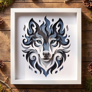 May include: A framed paper art piece featuring a layered, multi-dimensional wolf head design. The artwork uses shades of blue, gray, white, and black to create a stylized, flame-like pattern. The wolf has piercing blue eyes and a white snout.