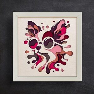 May include: A paper cut-out of a chihuahua wearing sunglasses, with pink, red, and brown layered paper creating a splash effect around the dog.