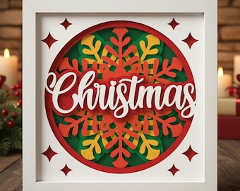May include: A framed Christmas artwork. The design features a layered circular arrangement with a red, green, and yellow snowflake design. The word "Christmas" is written in white script across the centre. The white frame has red diamond cutouts.