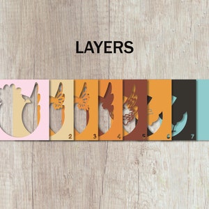 May include: Seven layers of paper cutouts, numbered 1 through 7, showing a rooster design. The layers are pink, cream, yellow, orange, brown, orange, black, and light blue.