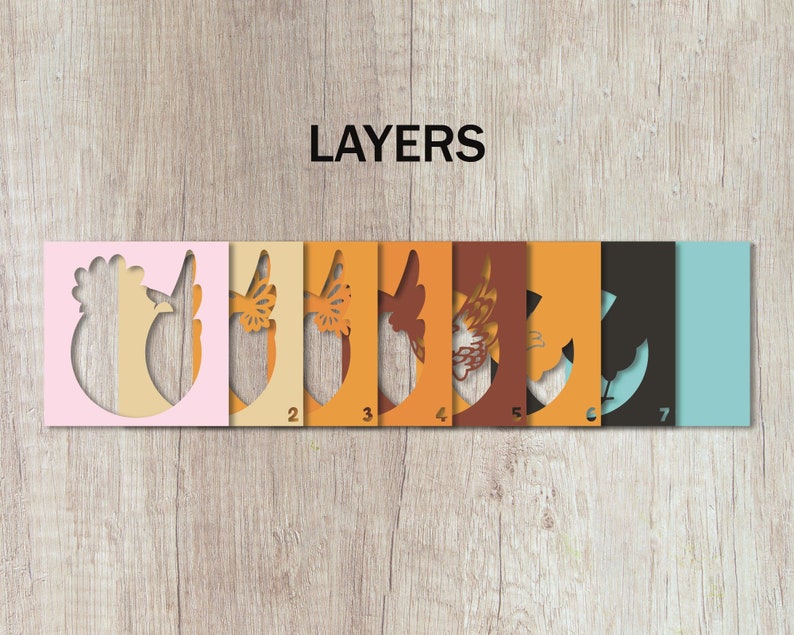 May include: Seven layers of paper cutouts, numbered 1 through 7, showing a rooster design. The layers are pink, cream, yellow, orange, brown, orange, black, and light blue.