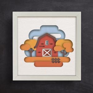 May include: A paper cut-out illustration of a red barn with a white door and windows, surrounded by orange and yellow trees and a blue sky. The barn is set against a white background.