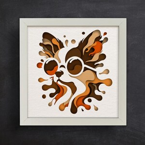 May include: A paper cut-out of a dog wearing sunglasses, with brown, orange, and white colors. The dog is surrounded by a splash of orange and brown paper.