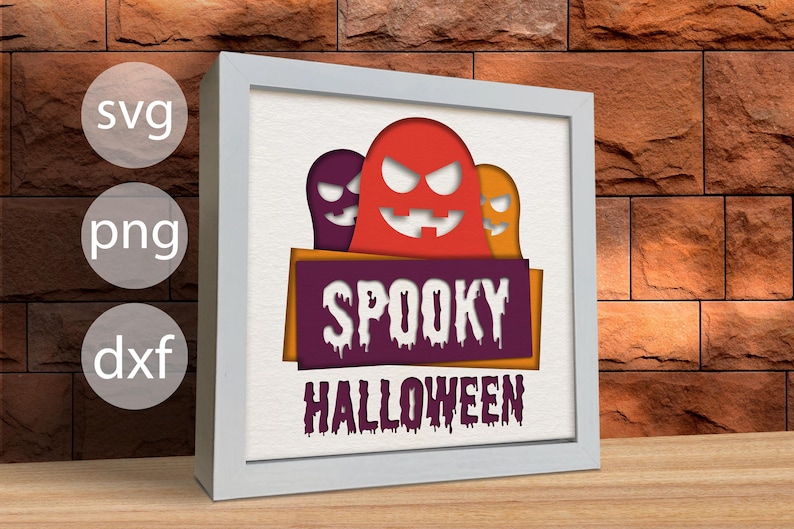 Pu&ograve; includere: Una cornice bianca con uno sfondo bianco e un design di carta tagliata in viola, arancione e rosso di tre fantasmi con il testo "Spooky Halloween".