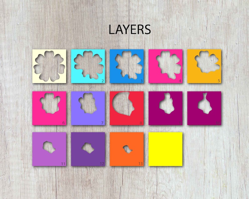 May include: Layers 1-13 of a paper flower craft project. The layers are cut from different coloured paper and arranged in a stack, with the largest layer on the bottom and the smallest layer on top. The layers are numbered 1-13.