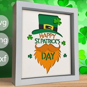 May include: A white frame with a green leprechaun hat, orange beard, and mustache. The text "Happy St. Patrick's Day" is written in green and orange letters.