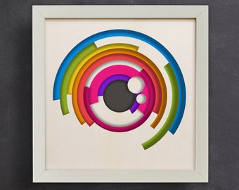 May include: A white frame with a colorful abstract design inside. The design is a series of concentric circles in shades of blue, green, yellow, orange, pink, purple, and black.