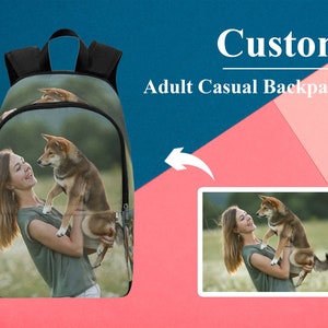 May include: A custom adult casual backpack featuring a photo of a person holding a dog. The photo shows a woman in a green shirt holding a brown and white dog in her arms. The background is a field of green grass.