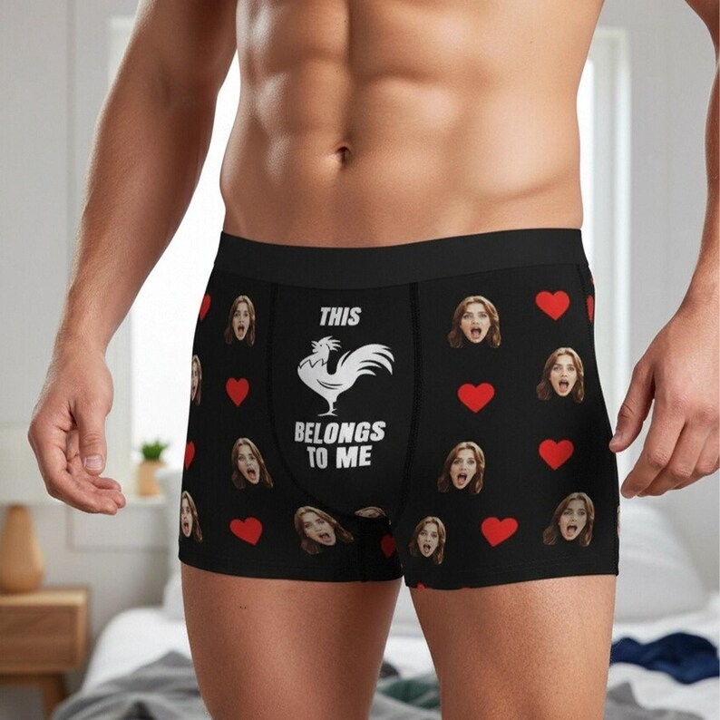 May include: Black boxer briefs with a repeating pattern of red hearts and surprised faces. The front of the briefs features a white rooster graphic and the text "THIS BELONGS TO ME."