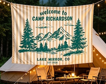 May include: A rectangular fabric banner with a beige and white vertical striped pattern. The design features dark green ink illustrations of pine trees and mountains, with the text "welcome to CAMP RICHARDSON" and "LAKE MIRROR, CO EST.2026".