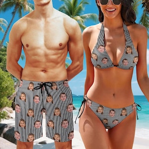 May include: A pair of black and white vertical striped swim trunks with a drawstring waist and a bikini set featuring a halter top and side-tie bottoms, both garments are printed with a repeating pattern of a child's face throughout the fabric.