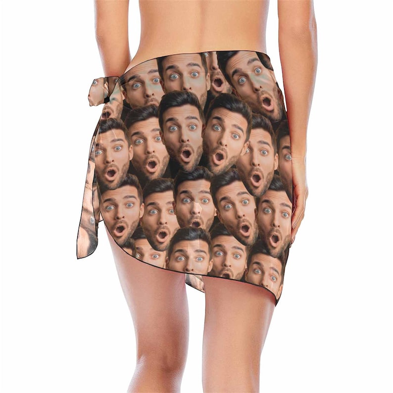 May include: A brown sarong with a repeating pattern of a man's face with a surprised expression.