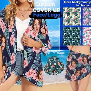 May include: A blue and white floral print cover-up with a custom face/logo option. The cover-up is shown on a model wearing it over a white tank top and denim shorts. The image also shows different background patterns to choose from, including floral, tropical, and flamingo prints. The text "Custom Cover Up Face/Logo" is displayed at the top of the image.