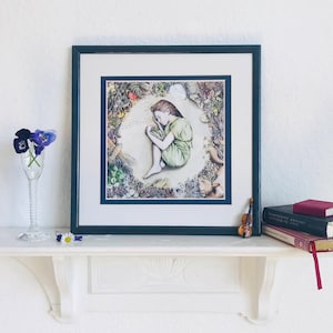 May include: A framed illustration of a girl sleeping in a circle of nature. The girl is wearing a green dress and has brown hair. The circle is made up of flowers, leaves, and animals.