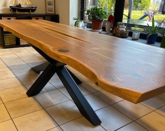 Mesa de comedor de roble macizo con patas centrales de metal.