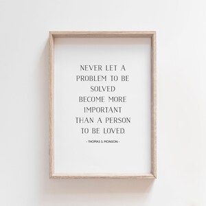 May include: A framed print with a quote by Thomas S. Monson: "Never let a problem to be solved become more important than a person to be loved."