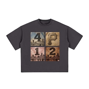 May include: A charcoal gray short-sleeve t-shirt featuring a central graphic composed of four square panels. The panels display the numbers 4, 1, 2, and the letter P, overlaid on images of a city skyline with bridges and a textured pattern.